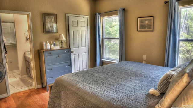 211 Roy Chisum Rd, Leakey, TX 78873 - bedroom featuring wood finished floors, a textured wall, and baseboards