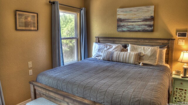211 Roy Chisum Rd, Leakey, TX 78873 - bedroom featuring a textured wall and baseboards