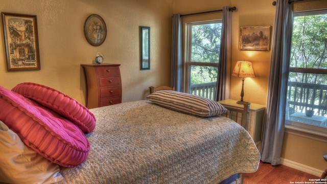 211 Roy Chisum Rd, Leakey, TX 78873 - bedroom featuring wood finished floors, baseboards, and a textured wall