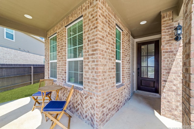 12531 Yancey, San Antonio, TX 78253 - doorway to property featuring a porch, brick siding, and fence
