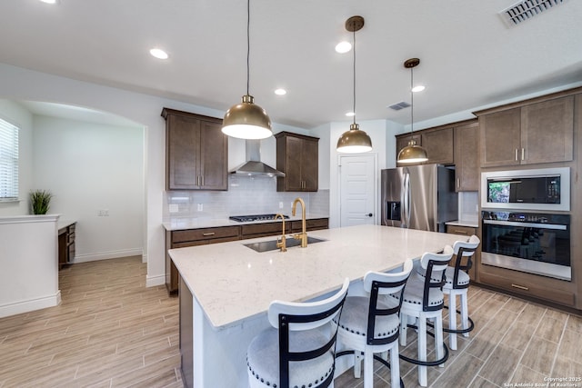 12531 Yancey, San Antonio, TX 78253 - kitchen with stainless steel appliances, wall chimney exhaust hood, a sink, light wood finished floors, and recessed lighting