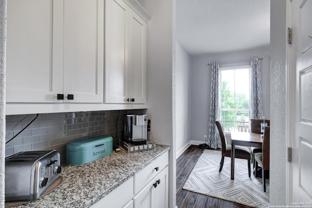 27210 Camellia, Boerne, TX 78015 - kitchen featuring backsplash, dark wood-type flooring, baseboards, white cabinets, and light stone counters