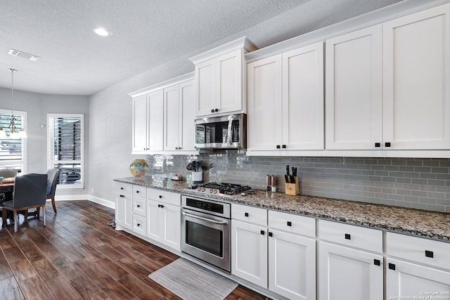 27210 Camellia, Boerne, TX 78015 - kitchen featuring appliances with stainless steel finishes, baseboards, tasteful backsplash, a textured ceiling, and stone counters