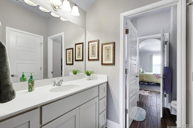 27210 Camellia, Boerne, TX 78015 - bathroom featuring wood finished floors, vanity, baseboards, ensuite bath, and toilet