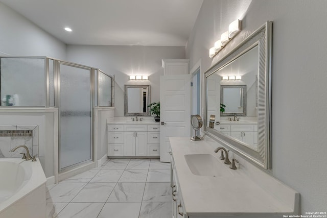 full bathroom with a shower stall, a bath, marble finish flooring, two vanities, and recessed lighting
