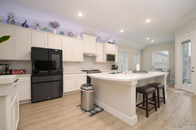 4609 Shackelford, Schertz, TX 78108 - kitchen with stainless steel appliances, a sink, lofted ceiling, decorative backsplash, and light wood finished floors