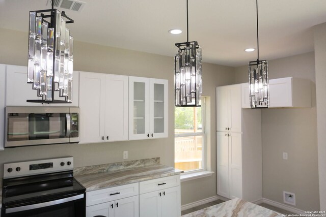 656 Canyon Cir, Canyon Lake, TX 78133 - kitchen featuring stainless steel appliances, a chandelier, baseboards, white cabinetry, and recessed lighting