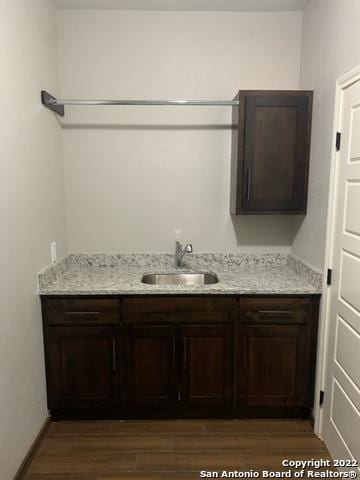 128 Woodbridge Ln, Vernia, TX 78121 - laundry room featuring a sink and dark wood-style flooring