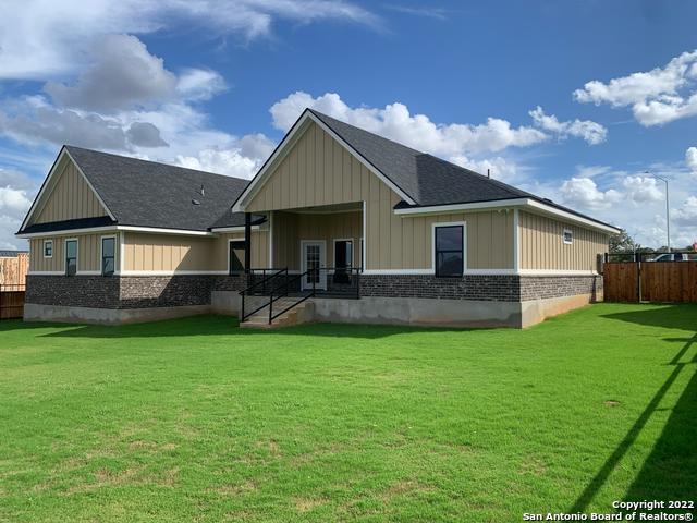 128 Woodbridge Ln, Vernia, TX 78121 - back of property with board and batten siding, a shingled roof, and brick siding