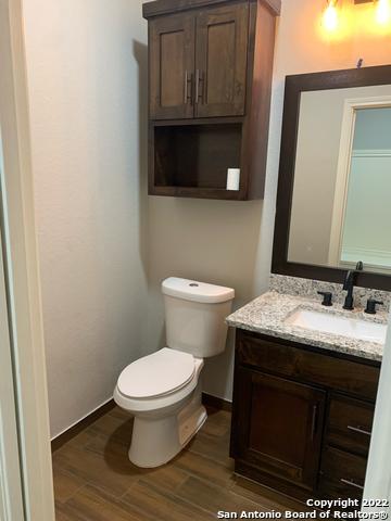 128 Woodbridge Ln, Vernia, TX 78121 - half bath featuring vanity, wood finished floors, toilet, and baseboards