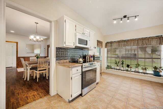 104 Holly Hl, Ingram, TX 78025 - kitchen with stainless steel electric stove, white microwave, white cabinetry, a chandelier, and tasteful backsplash