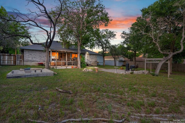 104 Holly Hl, Ingram, TX 78025 - yard at dusk featuring a patio