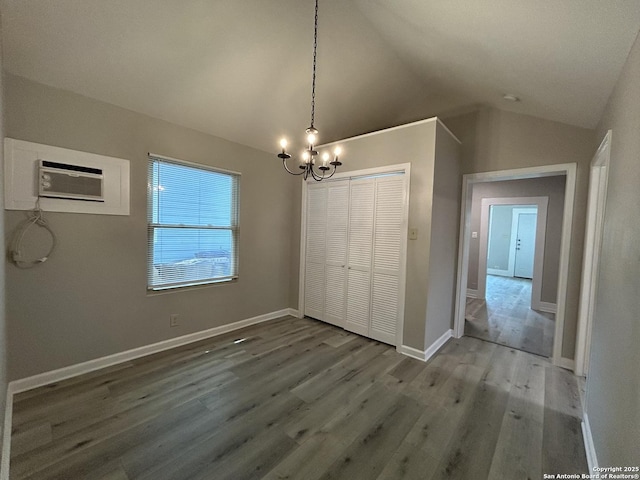 270 Oelkers, San Antonio, TX 78204 - unfurnished dining area with a chandelier, wood finished floors, a wall mounted AC, vaulted ceiling, and baseboards