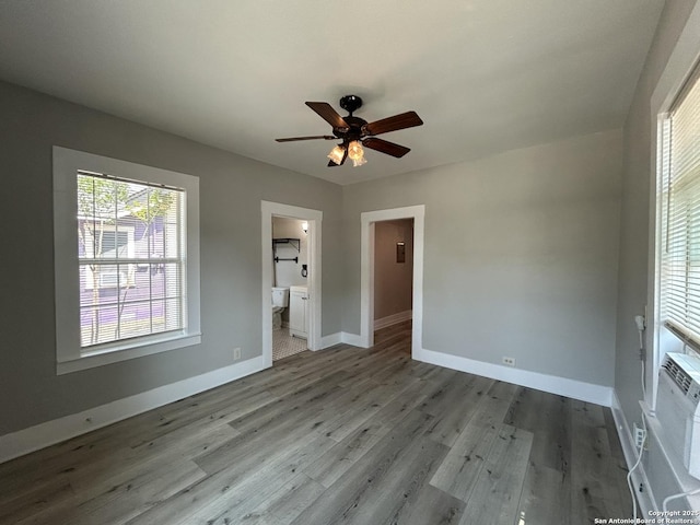 270 Oelkers, San Antonio, TX 78204 - unfurnished bedroom featuring baseboards, wood finished floors, connected bathroom, and ceiling fan
