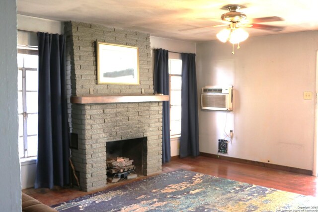 1306 Mountain Vw, Pipe Creek, TX 78063 - living area featuring ceiling fan, baseboards, wood finished floors, a brick fireplace, and an AC wall unit