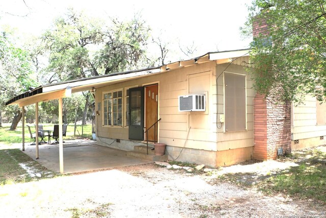 1306 Mountain Vw, Pipe Creek, TX 78063 - view of front facade with entry steps, an attached carport, a chimney, driveway, and a patio