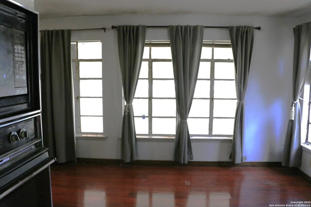 1306 Mountain Vw, Pipe Creek, TX 78063 - unfurnished room with dark wood finished floors and plenty of natural light