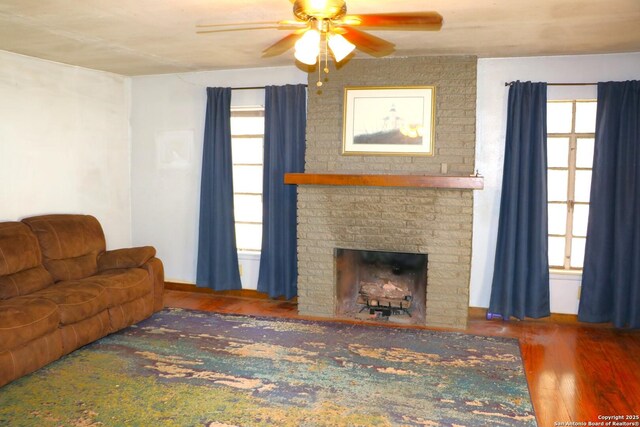 1306 Mountain Vw, Pipe Creek, TX 78063 - living room featuring ceiling fan, wood finished floors, a fireplace, and baseboards