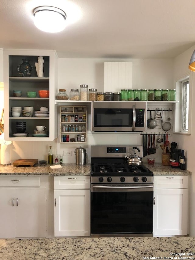345 Westminster, San Antonio, TX 78228 - kitchen with appliances with stainless steel finishes, open shelves, white cabinets, and light stone countertops