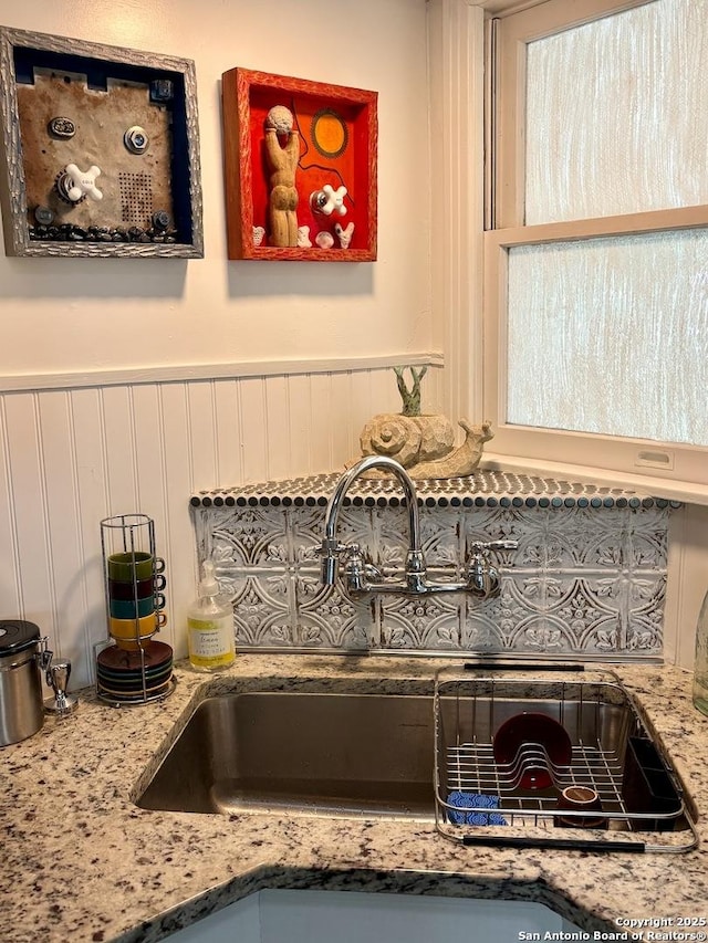 345 Westminster, San Antonio, TX 78228 - kitchen view of a sink, backsplash, pot filler, light stone counters, and wainscoting