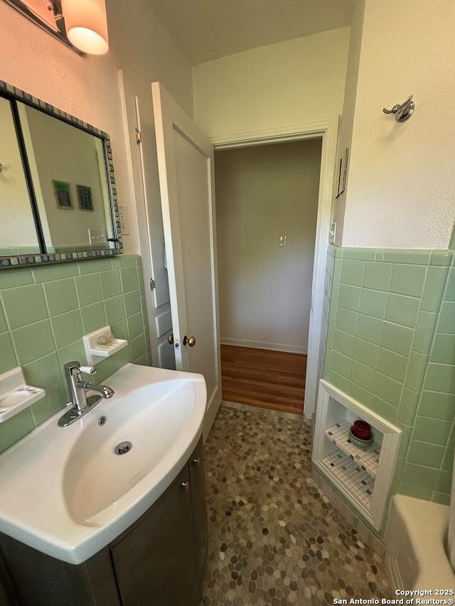 345 Westminster, San Antonio, TX 78228 - bathroom with tile walls, vanity, a wainscoted wall, and a tub to relax in