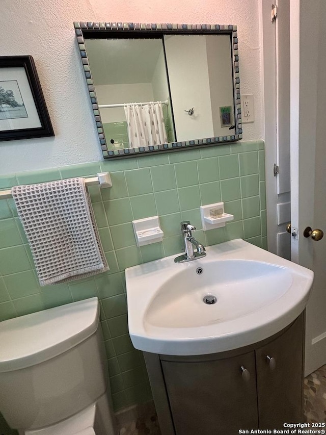 345 Westminster, San Antonio, TX 78228 - full bathroom featuring tile walls, toilet, a wainscoted wall, and vanity