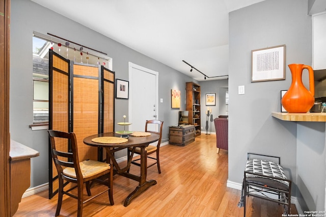 2811 Woodbury Unit 106, San Antonio, TX 78217 - dining room featuring light wood-type flooring, baseboards, and rail lighting