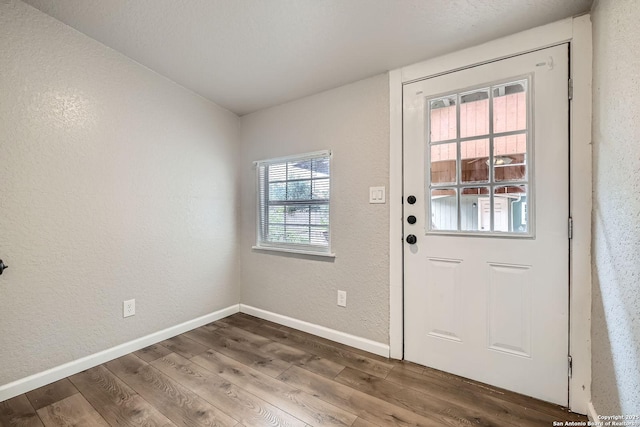 1022 Vickers Ave, San Antonio, TX 78211 - doorway featuring wood finished floors, a textured wall, and baseboards