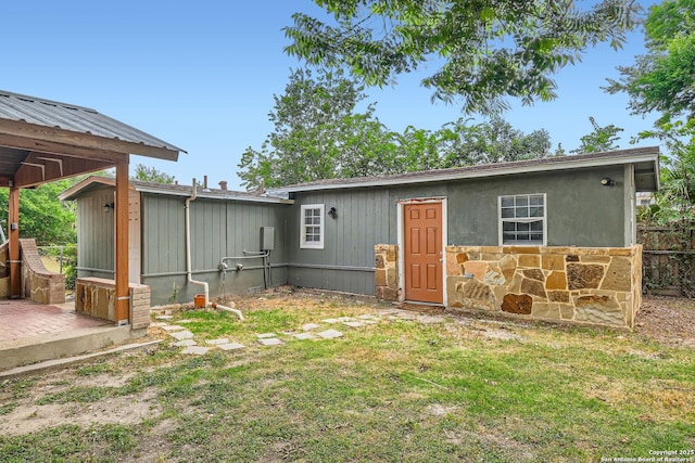 1022 Vickers Ave, San Antonio, TX 78211 - back of house with a yard and stone siding