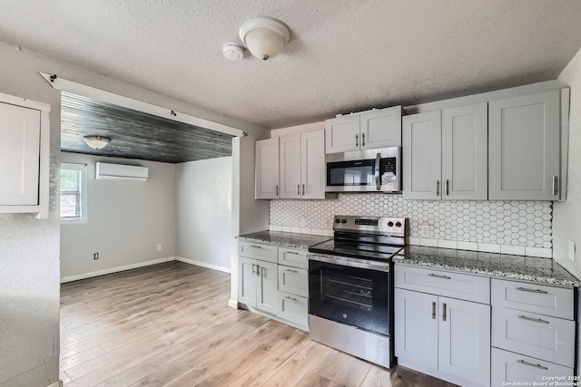 1022 Vickers Ave, San Antonio, TX 78211 - kitchen with stainless steel appliances, backsplash, light wood-style floors, stone countertops, and a textured ceiling