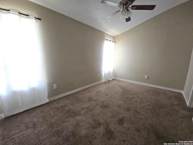 carpeted empty room featuring ceiling fan, lofted ceiling, a textured ceiling, and baseboards