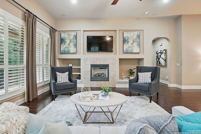 143 Roseheart, San Antonio, TX 78259 - living area with a ceiling fan, wood finished floors, arched walkways, a tiled fireplace, and built in features