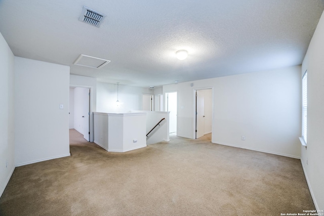 11023 Gilpin, Helotes, TX 78023 - spare room featuring light colored carpet, attic access, baseboards, and a textured ceiling