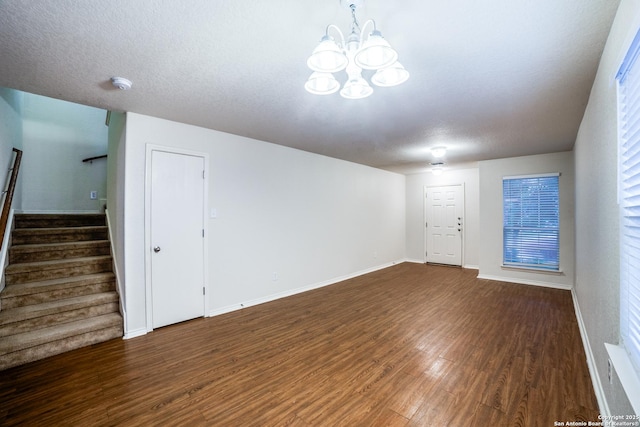 11023 Gilpin, Helotes, TX 78023 - unfurnished living room with a chandelier, wood finished floors, stairway, baseboards, and a textured ceiling