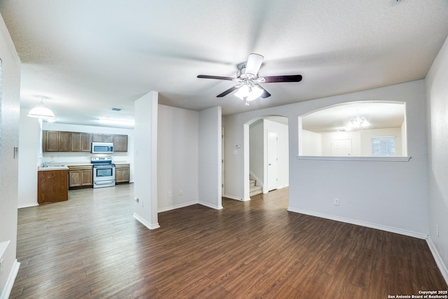 11023 Gilpin, Helotes, TX 78023 - unfurnished living room featuring baseboards, a ceiling fan, dark wood-style flooring, and arched walkways