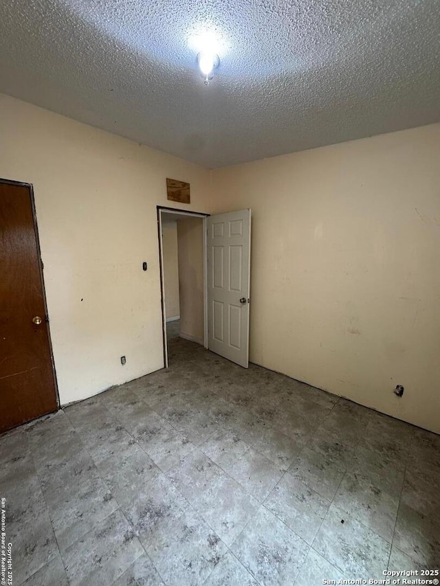 1702 Westmar, San Antonio, TX 78227 - unfurnished bedroom with a textured ceiling and a closet