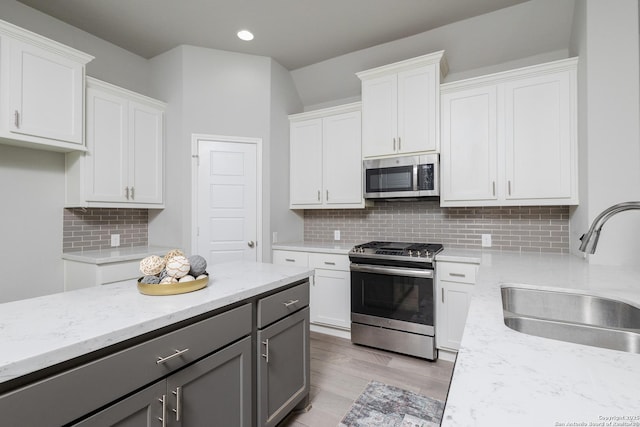 14703 Running Wolf, San Antonio, TX 78245 - kitchen with stainless steel appliances, a sink, gray cabinetry, white cabinets, and recessed lighting