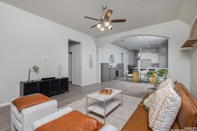 14703 Running Wolf, San Antonio, TX 78245 - living area featuring arched walkways, ceiling fan, light wood finished floors, and baseboards