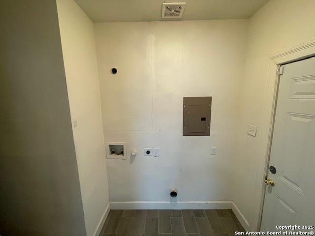438 Vanderbilt, San Antonio, TX 78210 - clothes washing area featuring electric panel, hookup for an electric dryer, baseboards, hookup for a washing machine, and wood finished floors