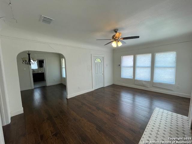 438 Vanderbilt, San Antonio, TX 78210 - unfurnished living room with arched walkways, dark wood-type flooring, ceiling fan, baseboards, and a chandelier