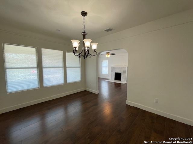 438 Vanderbilt, San Antonio, TX 78210 - unfurnished dining area featuring a chandelier, a tile fireplace, baseboards, and a ceiling fan