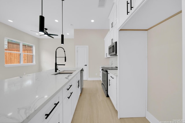 kitchen featuring stainless steel appliances, a sink, light stone countertops, ceiling fan, and recessed lighting