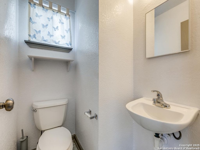8227 Grand Bnd, San Antonio, TX 78250 - half bathroom featuring toilet and a sink