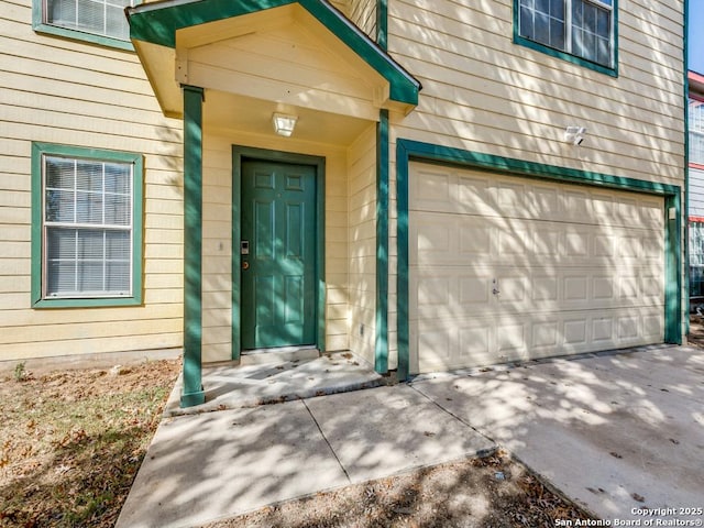 8227 Grand Bnd, San Antonio, TX 78250 - view of exterior entry featuring an attached garage and concrete driveway