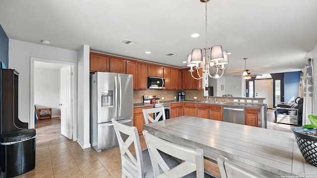760 Guna, New Braunfels, TX 78130 - kitchen with appliances with stainless steel finishes, a chandelier, a sink, a peninsula, and decorative backsplash