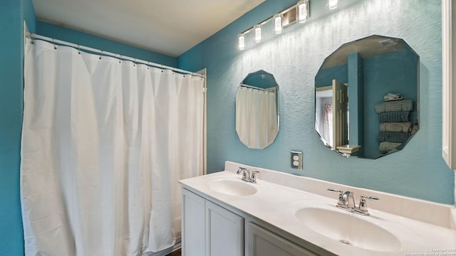 760 Guna, New Braunfels, TX 78130 - full bath featuring a textured wall, double vanity, and a shower with curtain