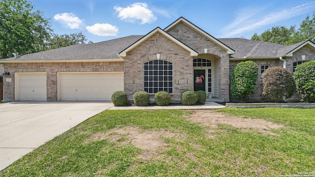14534 Gunter Ave, San Antonio, TX 78254 - view of front facade with driveway, an attached garage, brick siding, and roof with shingles