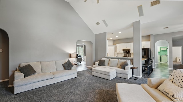 14534 Gunter Ave, San Antonio, TX 78254 - living room featuring arched walkways, high vaulted ceiling, baseboards, and dark wood finished floors