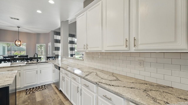 14534 Gunter Ave, San Antonio, TX 78254 - kitchen with a sink, dishwasher, light wood finished floors, decorative backsplash, and white cabinetry