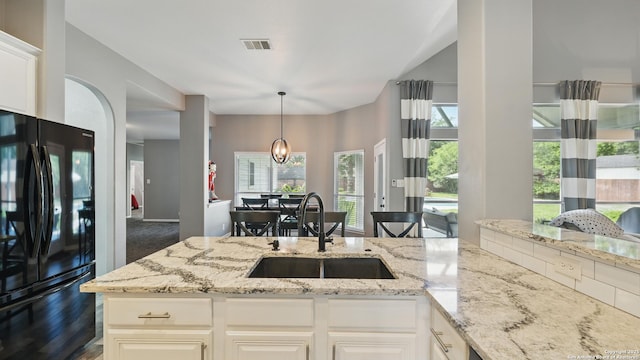14534 Gunter Ave, San Antonio, TX 78254 - kitchen featuring freestanding refrigerator, a sink, light stone counters, and decorative light fixtures